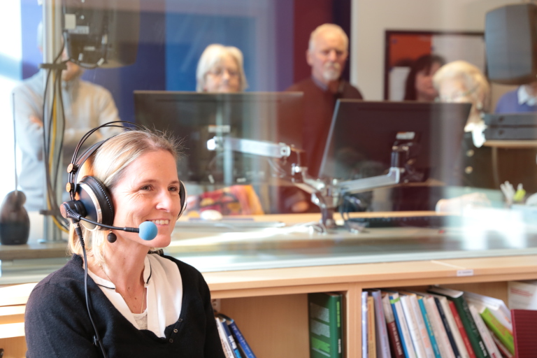 Frau im Gästestudio Wien lächelt beim Tag der offenen Tür ins Mikrofon