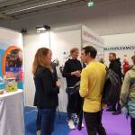 Antonia Kollmann im Gespräch mit Besuchern der SENaktiv vor dem Messestand.