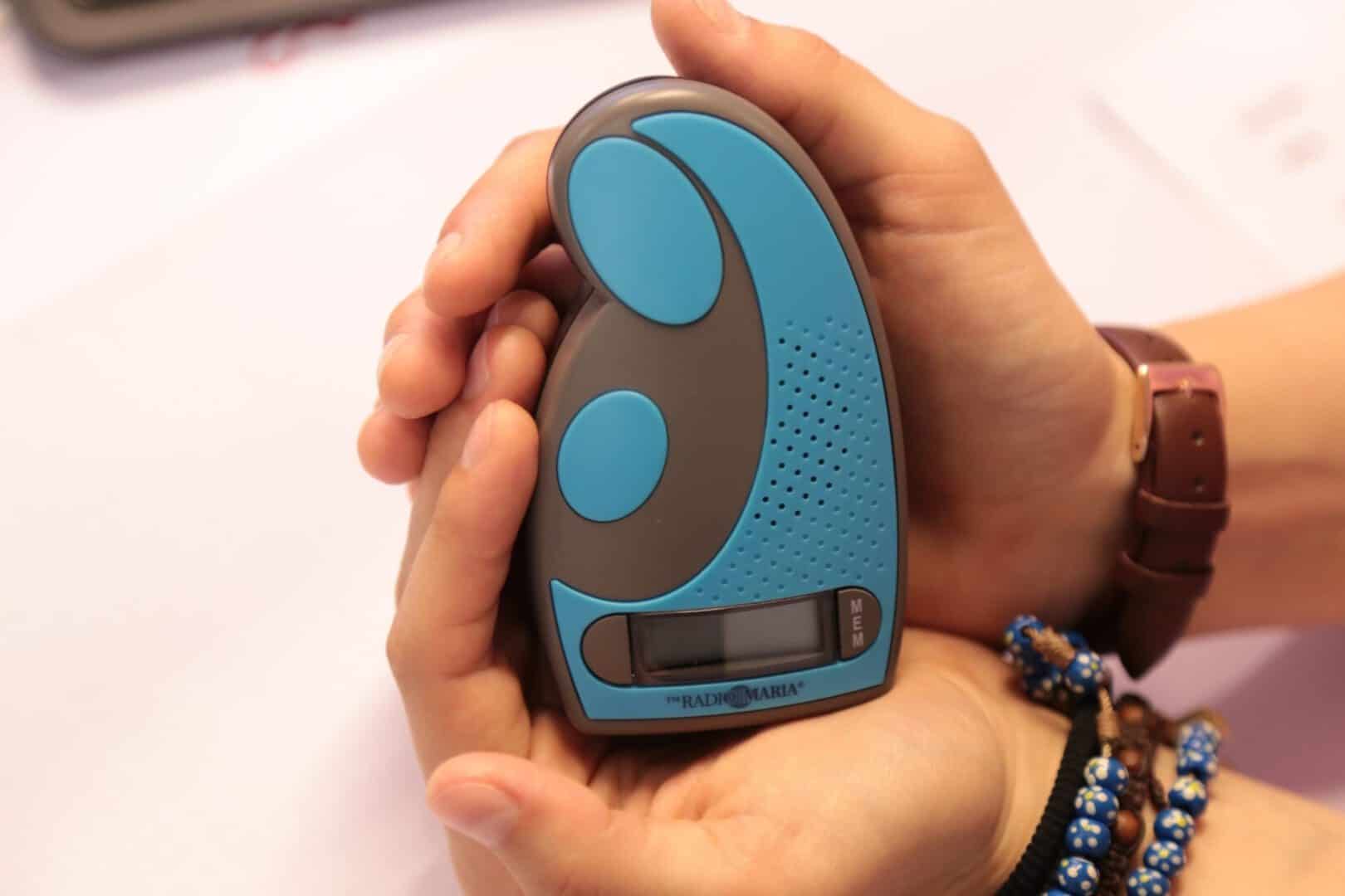 Das blaue Muttergottesradio in den Händen einer Person